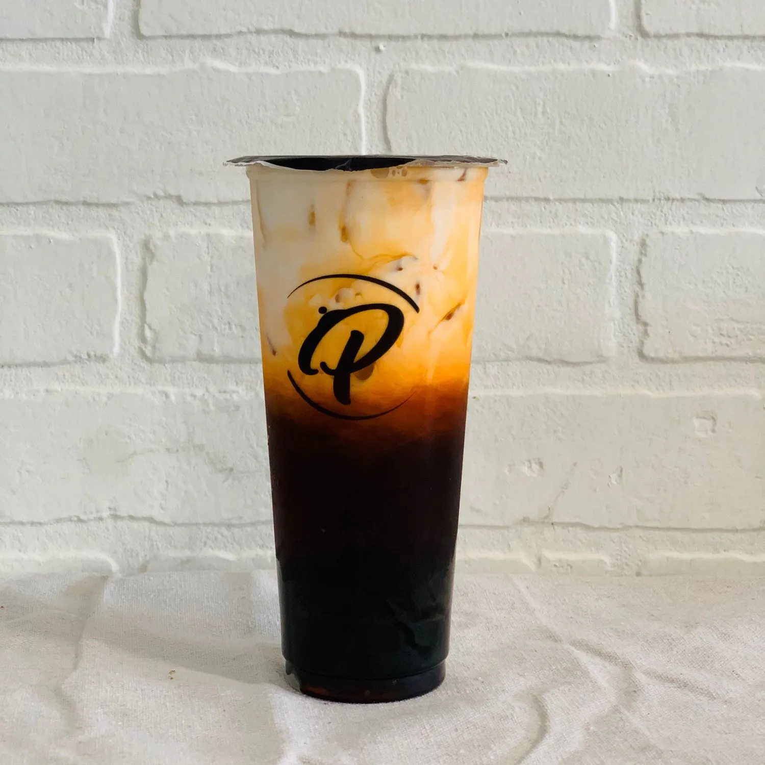 Creamy Thai milk tea with ice and layered colors at Kaiju Ramen & Curry, a Japanese Curry Restaurant in Isla Vista